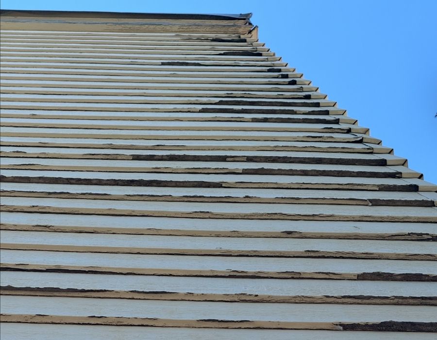 A closeup of the side on a house that needs to be redone.